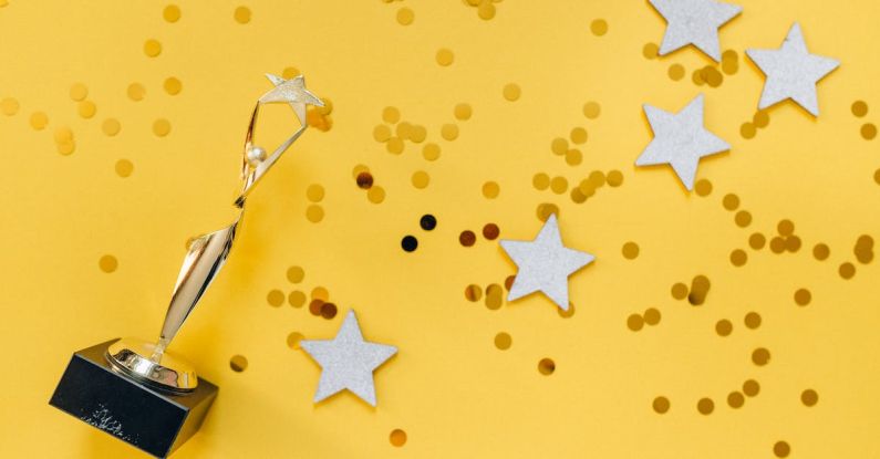 Rewards - Golden Statuette and Stars on Yellow Background