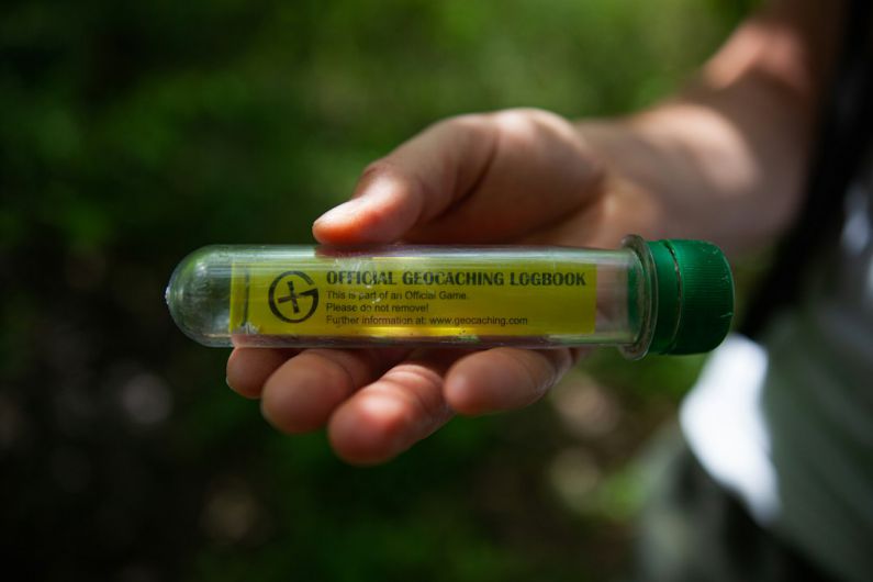 Geocaching - person holding yellow and green plastic bottle